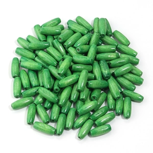 Macro shot of olive-shaped grass green wooden beads with smooth texture and drill hole