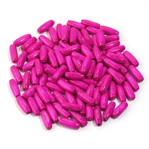 Close-up of bright rose pink oval maple wood beads with holes for DIY jewelry making