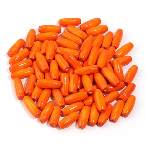 Macro shot of polished orange oval capsule wood beads with glossy finish and central hole