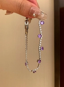 Detailansicht eines eleganten silbernen Armbands mit lila Zirkonia und sicherem Verschlussglied.