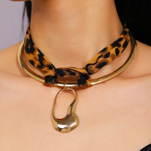 Detail view of leopard print ribbon choker with gold liquid metal irregular pendant