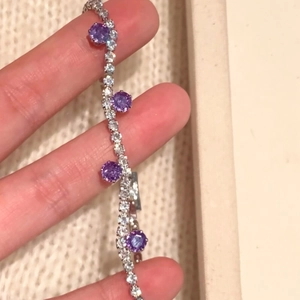 Nahaufnahme des funkelnden lila Zirkonia-Armbands mit silberfarbenem Ketten-Detail