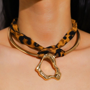 Close-up of leopard print ribbon choker with irregular liquid metal pendant detail