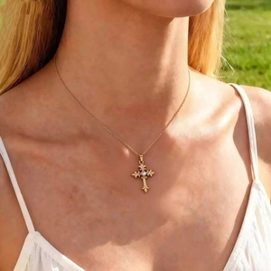 Elegante collar con colgante de cruz de acero inoxidable lucido por una modelo al aire libre