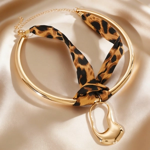 Close-up of leopard print silk ribbon choker with irregular golden liquid metal pendant