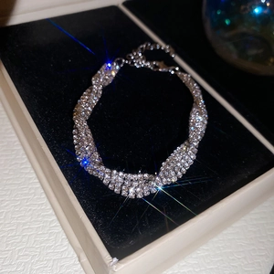 Détail d'un bracelet géométrique multicouche en strass argenté avec fermoir mousqueton