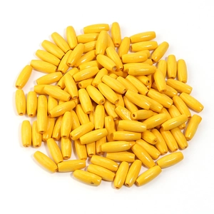 Macro shot of pile of yellow oval maple wood beads for DIY jewelry and necklace crafting
