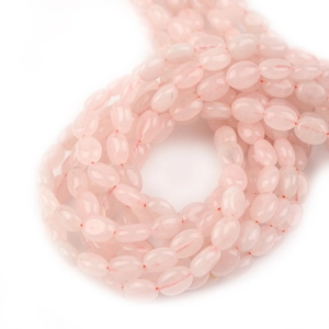 Macro-opname van ovale rozenkwarts kralen met natuurlijke texturen voor DIY-sieraden
