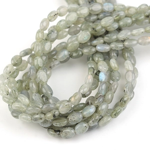 Macro-opname van platte ovale labradoriet kralen met blauwe glans voor DIY-sieraden maken
