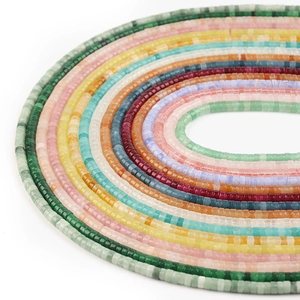 Macro view of colorful 4x2mm agate crystal spacer beads arranged in a circular pattern