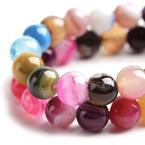 Gros plan macro de perles rondes en agate rayée colorée avec texture polie brillante