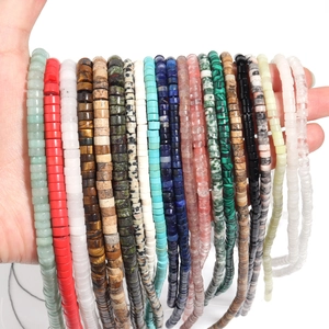 Hand holding assorted natural stone heishi spacer beads for DIY jewelry making
