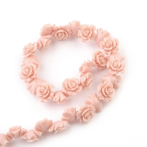 Macro detail of matte pink resin camellia beads arranged in a spiral for DIY jewelry