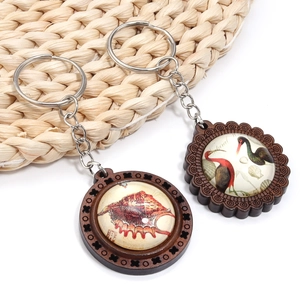 Detail of vintage wooden keychain pendants with glass cabochons and natural illustrations