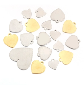 Macro detail of gold and silver heart-shaped stainless steel charms for DIY jewelry making
