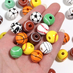 Close-up of mixed sports ball wooden beads for DIY bracelets and crafts in palm