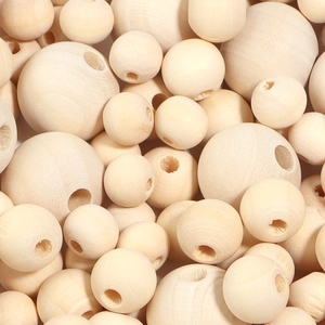 Close-up of natural unfinished round wooden beads with pre-drilled holes for DIY crafts