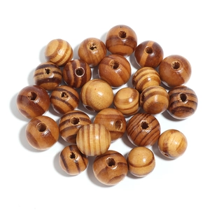 Macro view of round striped pine wood beads with natural texture and vertical drill holes