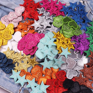 Close-up of colorful glitter star and heart embroidery patches for DIY clothing decor