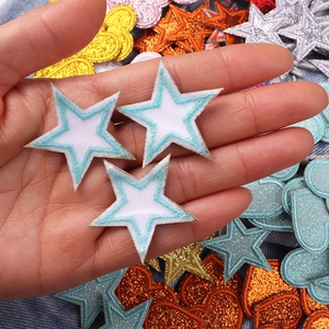 Macro view of colorful glitter star and heart embroidery patches for DIY clothing