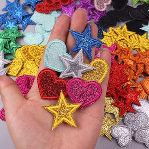 Close-up of glitter star and heart embroidery patches for DIY clothing decoration