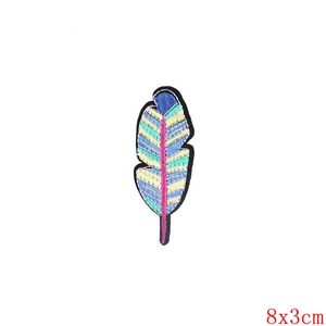 Vue détaillée d'un écusson brodé en forme de plume colorée, dimensions 8x3cm