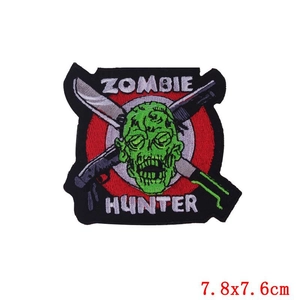 Close-up of Zombie Hunter embroidered punk patch with green zombie head and crossed knives