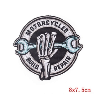 Close-up of vintage punk motorcycle patch with skeleton hands and wrench embroidery