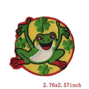 Macro detail of cartoon frog and shamrock embroidery patch with dimension 2.76x2.57 inches