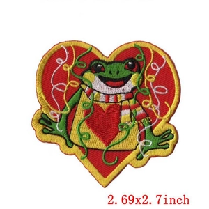 Macro shot of 2.69x2.7 inch cartoon green frog embroidery patch with a red heart backdrop