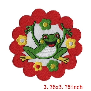 Close-up of a round cartoon frog embroidered patch with floral border measuring 3.76 inches