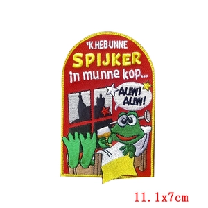 Detailed macro view of green frog embroidery patch with yellow border for carnival apparel