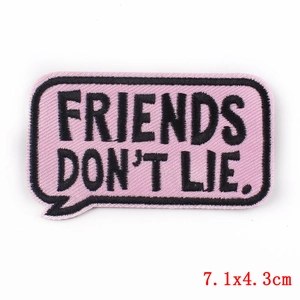 Pink embroidered patch with Friends Don't Lie text in a comic bubble design