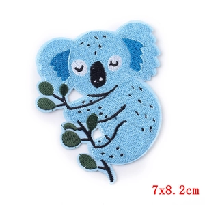 Detail view of cartoon blue koala embroidery patch measuring 7x8.2cm on white background