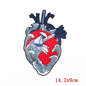 Detail of anatomical heart embroidery patch with ocean waves and 14.2x9cm size label