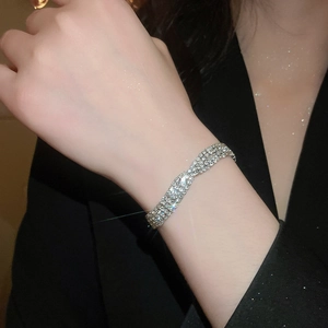 Gros plan détaillé d'un bracelet géométrique torsadé en strass brillant au poignet