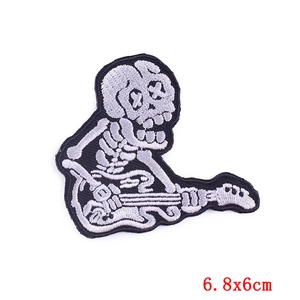 Macro shot of skull playing guitar embroidery patch with fine stitching and 6.8x6cm dimensions