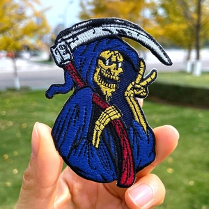 Detailed close-up of a grim reaper embroidered patch with high-quality blue thread stitching