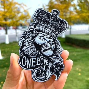 Macro detail of lion king embroidery patch with One Love text for DIY clothing