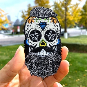 Macro detail of high-density punk skull embroidery patch with blue diamond eyes