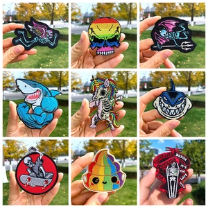 Détails de divers écussons brodés avec des motifs de crânes arc-en-ciel et licornes