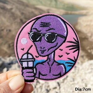 Close-up of 7cm round embroidered patch with purple alien design for DIY denim jackets