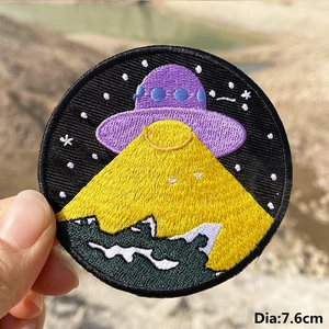 7.6cm embroidered UFO patch featuring sci-fi flying saucer over green mountains