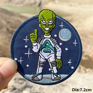 Detailed close-up of a 7.2cm alien astronaut embroidery patch with star background