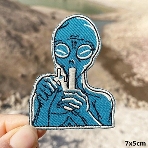 Macro shot of blue alien embroidery patch with 7x5cm size text on blurred background