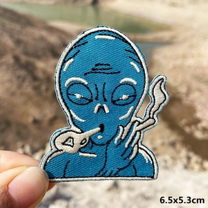 Detail view of a 6.5x5.3cm blue alien embroidery patch for DIY denim jacket repairs