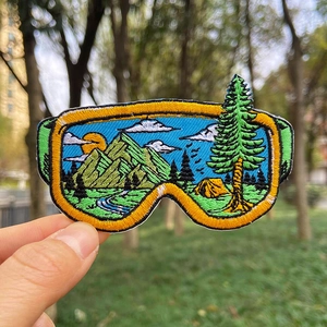 Écusson brodé en forme de masque de ski avec paysage de montagne, camping et rivière