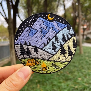 Détail de l'écusson brodé aventure étoilée avec scène de montagne et feu de camp
