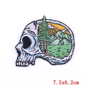 Close-up of skull adventure embroidery patch with mountain and pine tree details