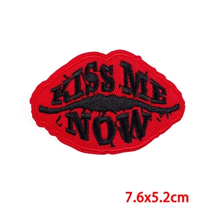Detailed close-up of red lips KISS ME NOW embroidery patch with fine stitching